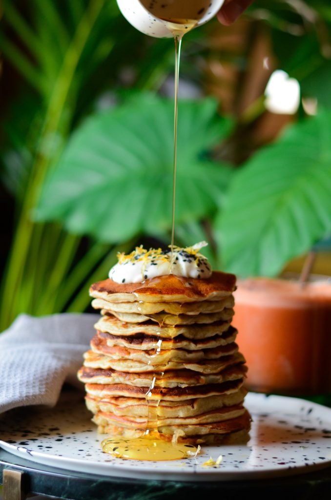 High stack of pancakes with syrup.